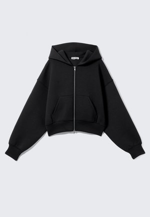 Black cropped hoodie made of soft fabric, featuring a front zipper, large pockets, a hood, and oversized sleeves for a relaxed fit.