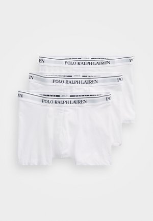 Três pares de boxers brancos com cinturas elásticas em preto e branco, com o texto "POLO RALPH LAUREN" em destaque.
