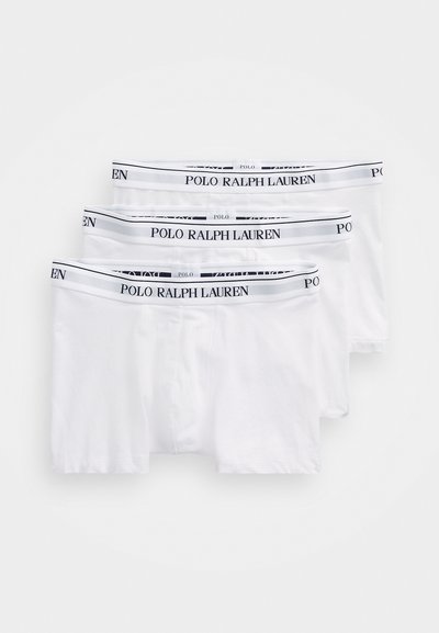 Drie paar witte boxershorts met zwart-witte elastische taillebanden waarop de tekst "POLO RALPH LAUREN" prominent is weergegeven.