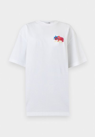 Λευκό oversized κοντομάνικο T-shirt με μικρή πολύχρωμη κεντητή λουλουδάτη διακόσμηση και καλλιγραφικό κείμενο στο πάνω αριστερό μέρος του στήθους.