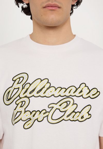 T-shirt en coton blanc présentant un grand logo stylisé "Billionaire Boys Club" en noir et jaune, agrémenté de strass.