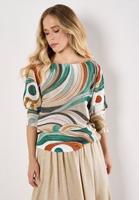 Top multicolore con motivi vorticosi in verde, arancione e crema, con maniche a tre quarti e scollo ampio, realizzato in un tessuto testurizzato.