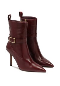 Stivaletti in pelle borgogna con punte appuntite, zip laterale e una fibbia in tono oro su una cinghia. Texture liscia e alti tacchi a stiletto.