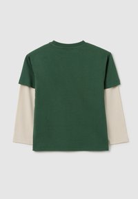 Groene korte mouwen t-shirt gelegen over een beige lange mouwen shirt. Katoenen stof met een ronde hals en een rechte snit.