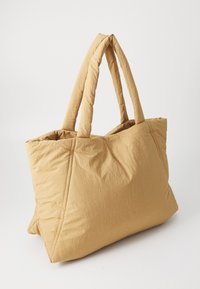 Borsa a tracolla trapuntata in una calda tonalità di giallo, caratterizzata da due manici corti, una texture soffice e decorazioni di cucitura triangolare sulla superficie.