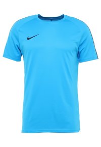 Jasnoniebieska koszulka sportowa Nike z krótkimi rękawami, okrągłym dekoltem i czarnym logo na lewej piersi. Gładka faktura i prosty design.