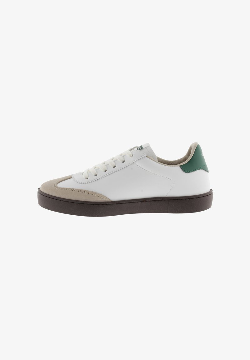 Zapatillas de cuero blanco con acentos de gamuza beige, tirador en verde y suela de goma marrón. Presenta un diseño con cordones y detalles de costura.
