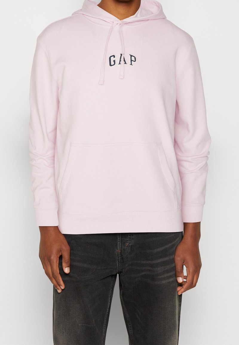 Felpa leggera rosa con tasca anteriore e cappuccio regolabile con cordino. Presenta un logo "GAP" blu scuro sul petto e polsini a coste.