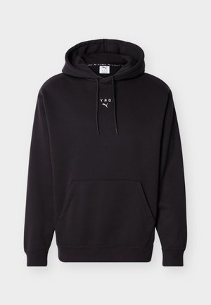 Juodas su gobtuvu džemperis su priekine kango kišene ir baltu užrašu „HYROX“ bei Puma logotipu ant krūtinės.