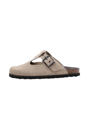 Zueco beige de ante con lados recortados, correa ajustable con hebilla metálica, plantilla de corcho y suela de goma negra.