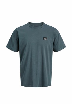 Obična siva majica kratkih rukava s okruglim izrezom, s malim crnim pravokutnim zakrpom na lijevoj strani prsa i oznakom "JACK&JONES" unutar ovratnika.