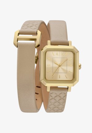 Goldfarbener quadratischer Uhr mit beigem strukturiertem Lederband, das ein geometrisches Muster und ein minimalistisches Zifferblatt mit goldenen Stundenmarkierungen und Zeigern aufweist.
