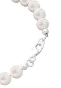 Gros plan sur un collier de perles composé de perles blanches rondes et d'un fermoir homard en argent sur fond blanc.