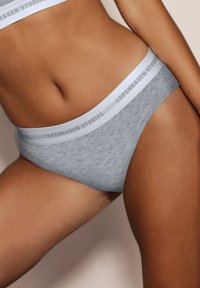 Bragă din bumbac gri cu un brâu de culoare gri deschis, având inscripția "COPENHAGEN STUDIOS." Textură catifelată și design cu croială clasică.