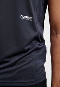 Dunkelgraues Performance-Tanktop aus leichtem, strukturiertem Stoff. Verfügt über eine enganliegende Passform und ein weißes "hummel"-Logo auf der Brust.