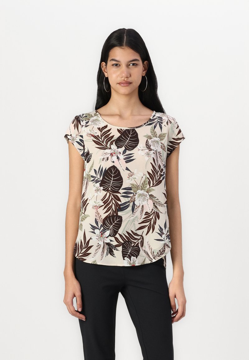 Blouse à manches courtes de couleur beige clair avec un motif floral sombre agrémenté de touches de vert et de rose, col rond et coupe décontractée.