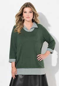 Maglia verde a maniche lunghe con colletto a righe e dettagli a righe nei polsini. Vestibilità ampia, tessuto testurizzato e orlo a righe in contrasto.