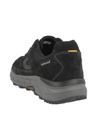 Schwarzer Wildleder- und synthetischer Wanderschuh mit einer dicken grauen Gummisohle, sichtbaren Nähten und einem gelben Akzent an der Ferse.