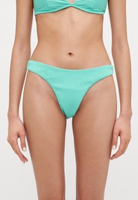 Ljusgrön ribbad bikiniunderdel med hög skärning och bred midjelinning, tillverkad i textilmaterial.
