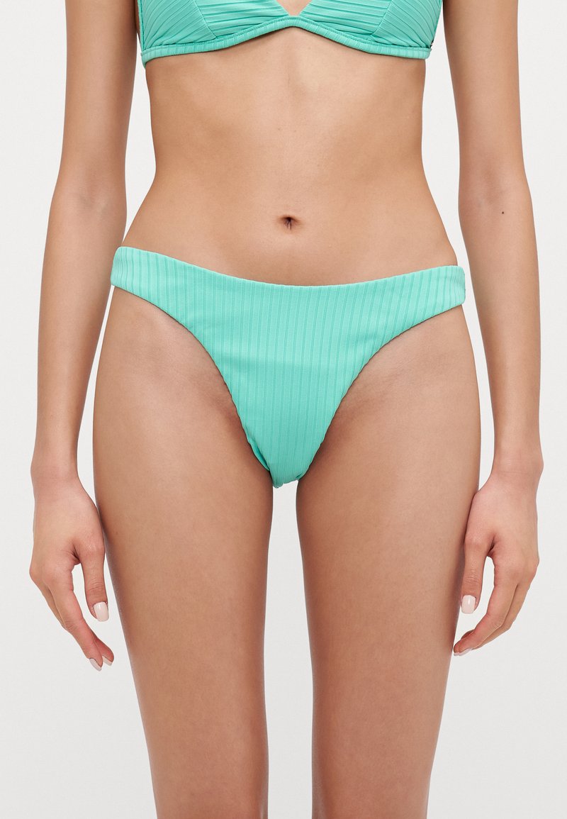 Ljusgrön ribbad bikiniunderdel med hög skärning och bred midjelinning, tillverkad i textilmaterial.