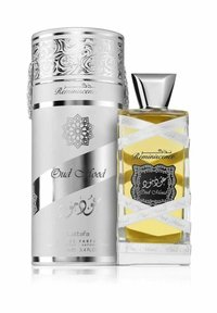 Elegant parfume flask i klart glas, sølvdetaljer og et dekorativt bånd. Inkluderer en metallisk sølv cylindrisk kapsel og udsmykket etikettering.
