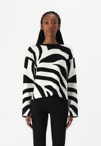 Mustavalkoruudullinen neulepaita, jossa on pitkät hihat, pyöreä pääntie ja reilu istuvuus, valmistettu pehmeästä neulosmateriaalista.