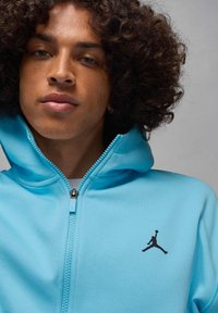 Felpa con cappuccio blu con cerniera, realizzata in tessuto morbido, con logo Jordan nero sul petto a sinistra e cerniera a contrasto.