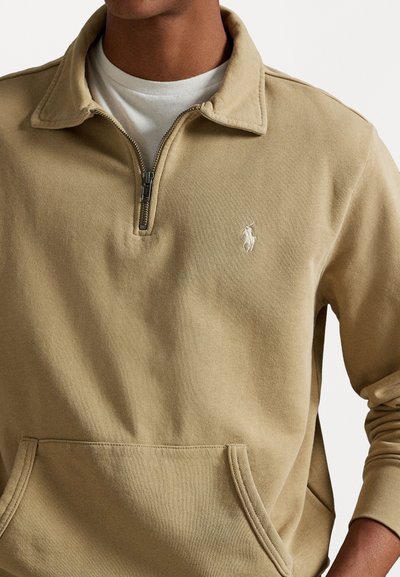 Beige pullover sweatshirt met een halve rits kraag, voorkantzak en geborduurd logo op de borst; gemaakt van zachte katoen stof.