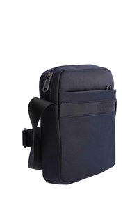 Bolso bandolera compacto de color azul marino con bolsillo frontal, cierre de cremallera y correa negra ajustable.