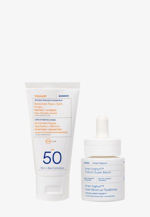 Crème solaire Korres Yoghurt SPF 50 pour le visage et les yeux et Smart Yoghurt Probiotic Super Serum avec compte-gouttes sur fond blanc.