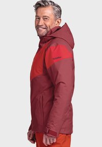 Rote wasserdichte Jacke mit Kapuze, kontrastierenden helleren roten Einsätzen und einem Logo auf dem Ärmel. Geprägter Stoff mit tailliertem Design.