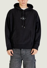Sudadera negra con capucha hecha de tela suave, con un bolsillo frontal, detalles de cordón y un gráfico del logo en el centro.