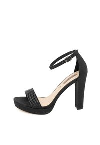 Sandalo nero con tacco alto caratterizzato da una finitura opaca, una cinghia alla caviglia testurizzata e una suola con piattaforma e una cinghia per le dita decorata.