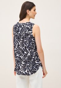 Top senza maniche in tessuto leggero con motivo foglia navy e bianco, scollo rotondo e un leggero design a orlo asimmetrico.