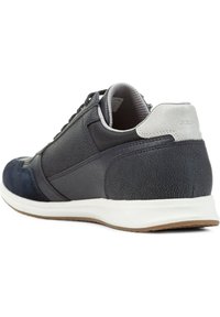 Zapatillas deportivas azul marino con materiales de cuero y ante, con un acento en el talón gris y suela de goma blanca. Diseño con cordones y acabado texturizado.