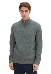Grauer Strickpullover mit einem Reißverschlusskragen, der mit einem strukturierten Muster und langen Ärmeln versehen ist. Der Stoff wirkt warm und hat ein lässiges Design.