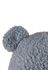 Close-up of soft, textured gray fabric shaped like a teddy bear ear on a white background.