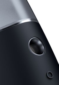 Zwart elektronisch apparaat met een gladde matte afwerking, een ronde luidsprekeropening en een zilverkleurig accent aan de bovenrand. Ronde hoeken en een minimalistisch ontwerp.