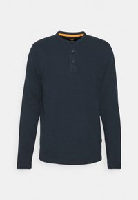 Mörk marinblå långärmad henleytröja för män med två-knappsstängning och orange detaljer inuti kragen, visad på vit bakgrund.