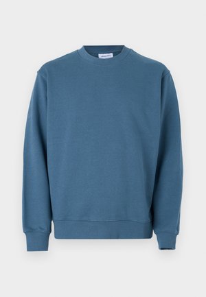 Sweatshirt en coton bleu avec un col rond, des poignets côtelés et un ourlet droit. Présente une texture lisse et une coupe décontractée.