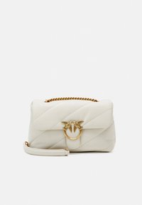 Bela prešita torbica z zlato verižico in zlatim zapahom v obliki ptice na sprednji preklopnici, postavljena na enobarvno belo ozadje.