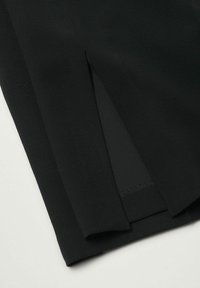 Černá látka s hladkým povrchem má mírné sklady. Design je minimalistický, bez dalších vzorů nebo akcentů.