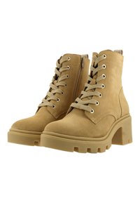 Botines de ante en tonalidad marrón claro con un tacón alto y grueso, punta redonda, diseño con cordones y detalle de cremallera lateral.