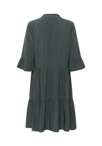 Rochie de culoare verde închis, lejeră, cu tiv stratificat cu volan și mâneci cu volane până la nivelul cotului, prezentată din spate pe un fundal alb.