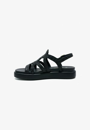 Sandalo con zeppa nero con cinturini intrecciati, punta aperta e chiusura con fibbia alla caviglia, progettato per un uso casual.