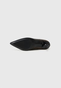 Chaussure à talon noire avec un bout pointu, dessus en cuir lisse et semelle en caoutchouc texturé. Design minimaliste avec des détails de couture discrets.