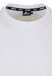 Hvit t-skjorte laget av bomull, med rund hals og et svart merke med hvit tekst rundt kragen. Enkel, uvanlig design.