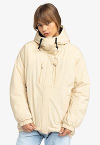 Giacca puffer beige chiaro con colletto alto, cappuccio regolabile, tasche frontali con zip, polsini elasticizzati e vestibilità rilassata. Materiale liscio e impermeabile.