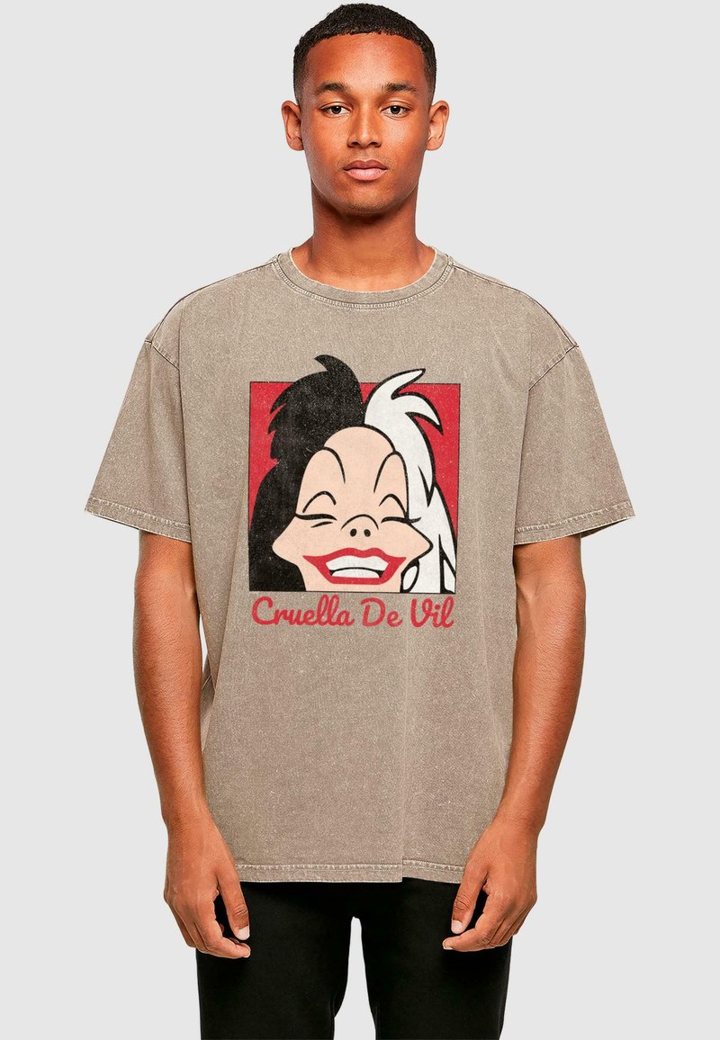 Beige ülemõõduline t-särk, mis on valmistatud puuvillast, ja millel on must-valge graafika Cruella De Vilist punase taustaga ning tekst all.