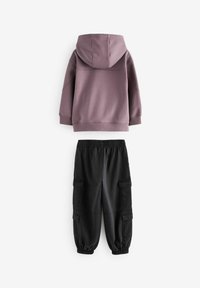 Sweat-shirt à capuche violet avec une poche kangourou, associé à un pantalon cargo noir avec des poches latérales et des poignets élastiques.